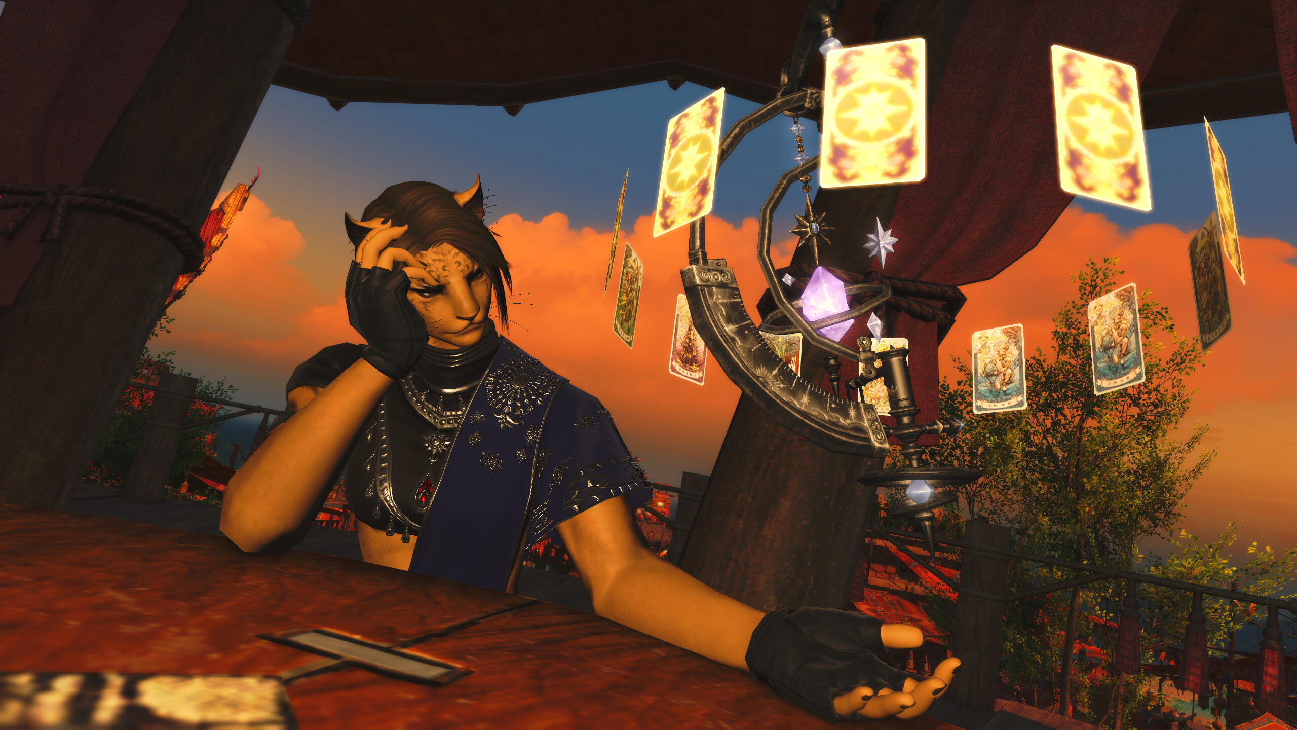 Kreja sitting at a table at dusk, half hunched over it. She has her head in her hand with her elbow on the table. In her other hand, her astroglobe hovers and she looks at it melancholic.